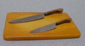 Two Kitchen Knives and a Bread Board